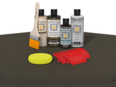 Retique It® Wood'n Finish Kit in charcoal for exterior wood projects, shown on a table with tools and wood surface.