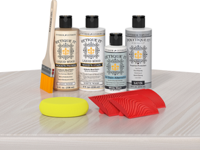 Retique It® Wood'n Finish Kit in White Wash with exterior top coat, displayed on table showcasing wood finishing products.