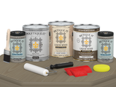 Retique It® Wood'n Finish Kit with four large driftwood-colored exterior top coat bottles on a table.