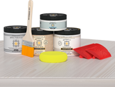 Retique It® Wood'n Finish Kit in White Wash, medium size, with exterior top coat and wood finish tools on a table.