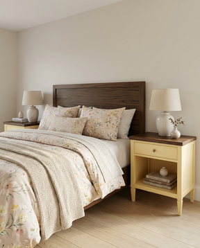 Bedroom with wooden headboard and matching nightstands, featuring floral bedding and lamps.